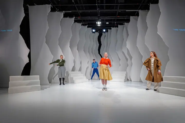 Gebärden der Geschichte mit Ensemble auf der hellen Bühne